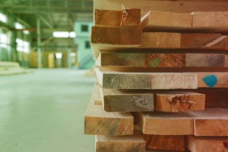 Warehouse or factory for sawing boards on sawmill indoors. Wood timber stack of wooden blanks construction material. Logging Industryの写真素材
