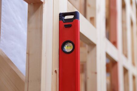 Accuracy and quality. Quality control of the construction of wooden building structures of a frame house. Measurement of vertical deviation of installed structures.の写真素材