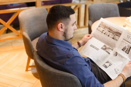 Man reading a newspaper in cafeの写真素材