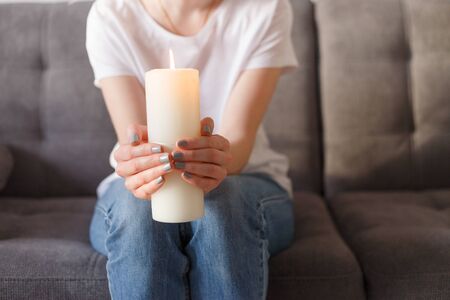 woman holding burning candle in her handsの写真素材