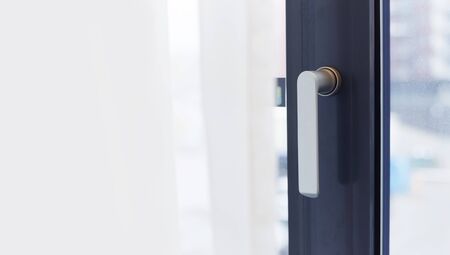 Aluminium window frame with metal handle. Copy space on a curtain for textの写真素材