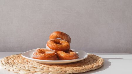 Glutton girl grabs donuts from a plate. Girls hand and plate with donuts.の写真素材