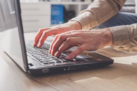Freelancer young man working on laptop at home during isolation periodの写真素材