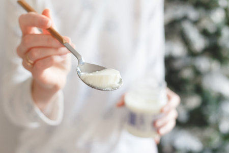 spoon with thermostat yogurt in a girl's hand.
