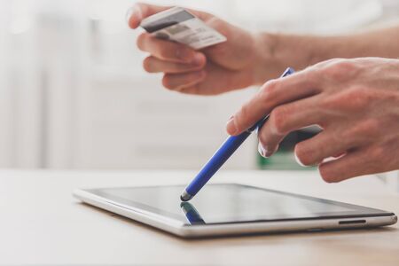 Man holding tablet pc and credit card at the table, shopping online.の写真素材