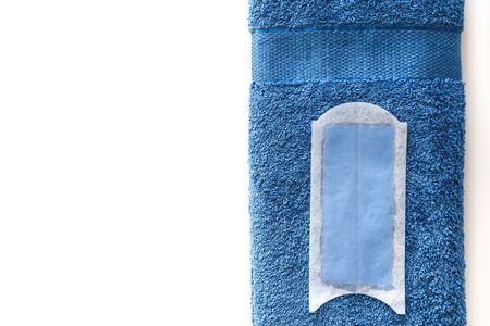 Disposable wax strip for depilation,on blue cotton towel isolated on white. Top view.の写真素材