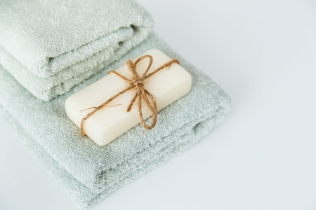 Solid soap corded on bath towels on white background with copy space.