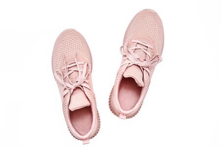 Pink female sneakers isolated on white background. Flat lay, top view. Sport casual shoesの写真素材