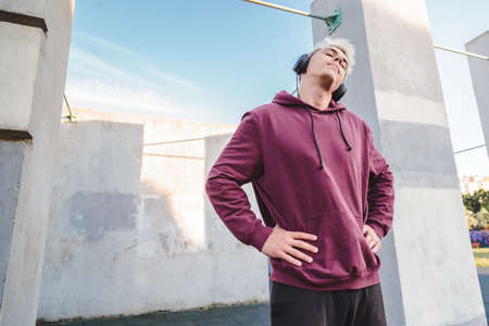 Sport man  doing neck rotation exercises and listening to music in headphonesの写真素材