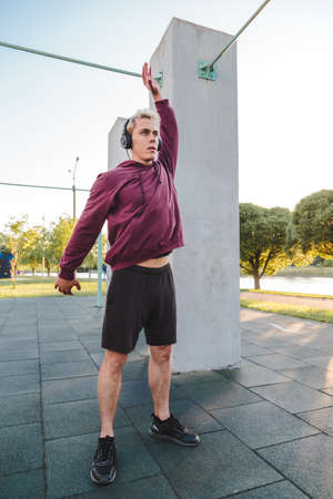 man doing exercise and listen to music in headphones.の写真素材