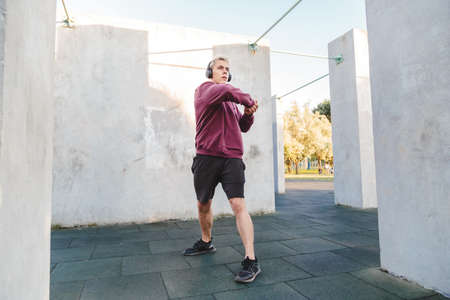 man doing exercise and listen to music in headphones.の写真素材