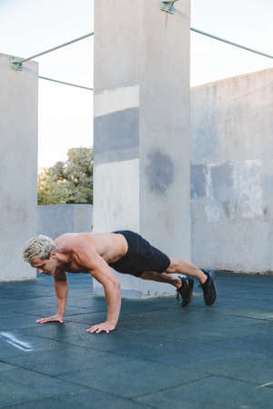 Young athletic man doing burpee outdoor.の写真素材