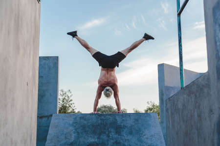 Handstand yoga pose by athlete man on the sport ground outdoors, natural lifestyle photo.の写真素材