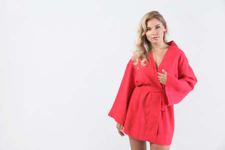 young elegant woman in red dress on white. Fashion studio shotの写真素材