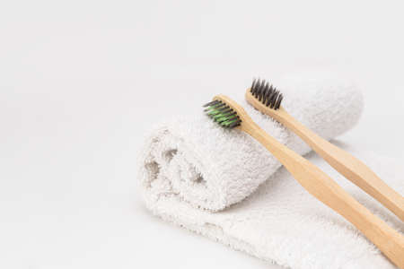 Wooden toothbrushes on white towel with copy space. Ecological material and dental careの写真素材