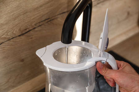 Water filter jug in kitchen sink, filling up.の写真素材