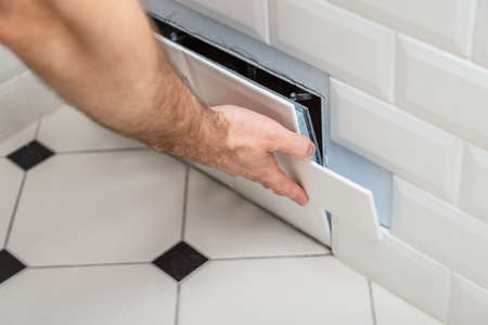Open hidden revision sanitary hatch on the wall of tile under the bathroomの写真素材