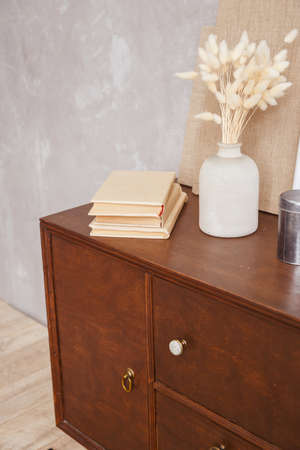 Retro cabinet with books and vase in home office interior on desk. Real photoの写真素材