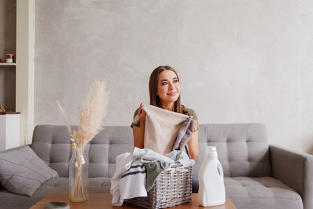 Girl enjoys clean and smelling towels after washing with new detergent gelの写真素材