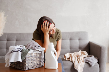 Young alone suffering woman tired from housework routineの写真素材