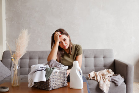 Young alone suffering woman tired from housework routineの写真素材