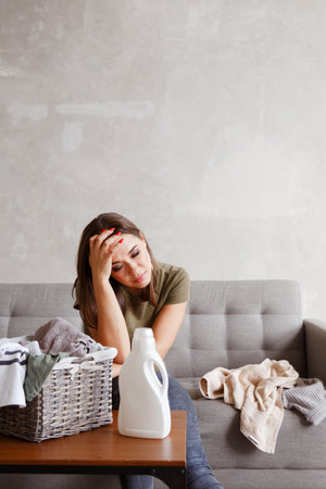 Young alone suffering woman tired from housework routineの写真素材