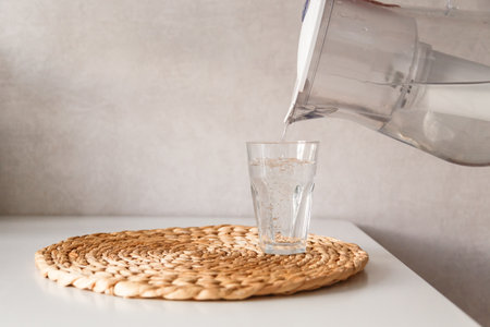 Pouring water from pitcher into a glassの写真素材