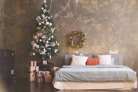 Christmas tree with a white bed in a bedroomの写真素材