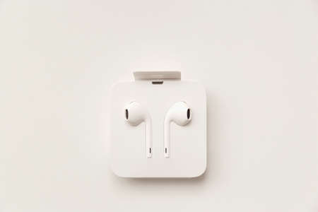 Modern white earphones packed into a box isolated on white backgroundの写真素材