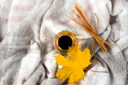 Home fragrance with sticks and maple leaf on wool blanketの写真素材