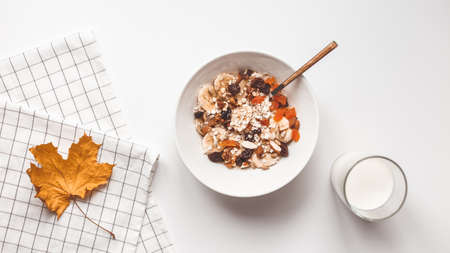 Carbohydrate healthy breakfast. Oatmeal with dried fruits on a white plate. View from aboveの写真素材