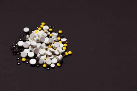 Medicines spilling out on dark gray background. Top view, flat lay. Healthcare, pharmacy, medicine conceptの写真素材