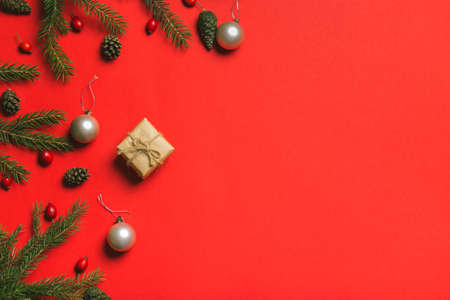 Christmas composition. Frame made of christmas gifts, pine branches, isolated on red background. Flat lay, top viewの写真素材