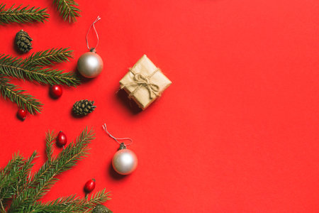 Christmas composition. Frame made of christmas gifts, pine branches, isolated on red background. Flat lay, top viewの写真素材