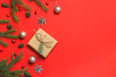 Christmas composition. Frame made of christmas gifts, pine branches, isolated on red background. Flat lay, top viewの写真素材