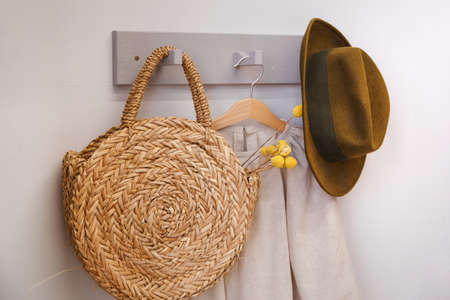 Hat and beach straw bag on a rustic hangerの写真素材