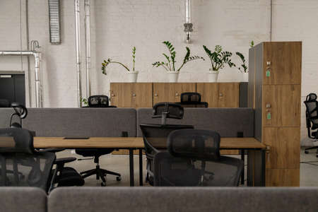 Interior of modern coworking space without people, containing tables and chairsの写真素材