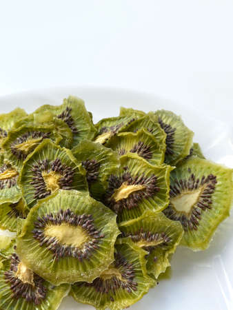 Dehydrated kiwi slices with sugar isolated on white plateの写真素材