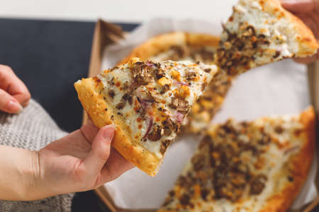 young couple eating pizza. Top view hands with pizzaの写真素材