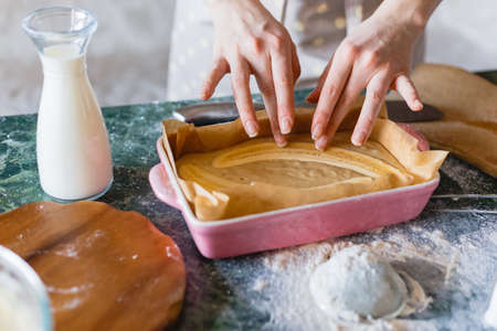 Raw cake batter with halved bananas in ceramic rectangle mold. Banana pie bakingの写真素材