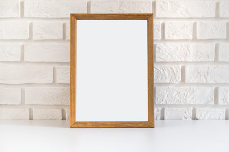 Blank wooden picture frame at the white brick wall with copy space.