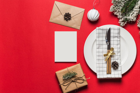 Christmas and New Year holiday table setting with envelope, gift box and blank card decoration....