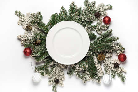 Empty white ceramic plate with fir branches and decoration. Flat lay christmas and new year concept. top view.の写真素材