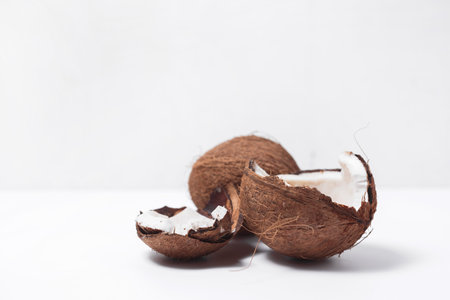 Coconut cracked in half on white background