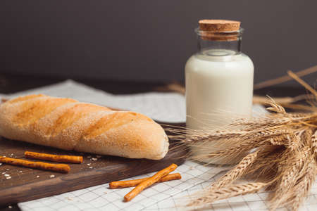 Ciabatta bread with milk bottle and ears of wheat.の写真素材