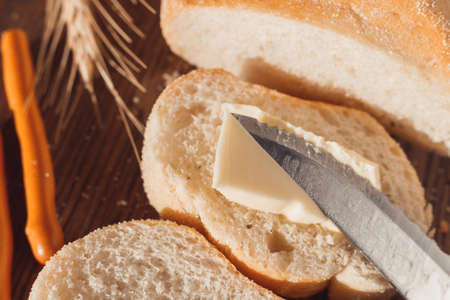 Ciabatta bread with ears of wheat. Spread butter on breadの写真素材