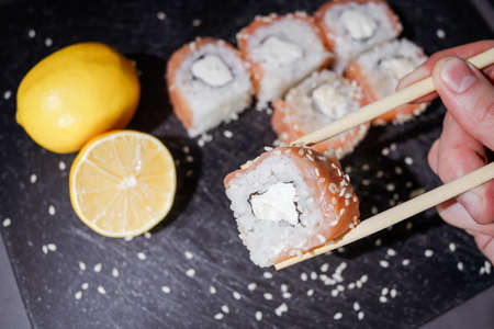 Sushi rolls set served on black board on dark background.の写真素材