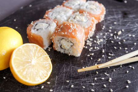 Sushi rolls set served on black board on dark background.の写真素材