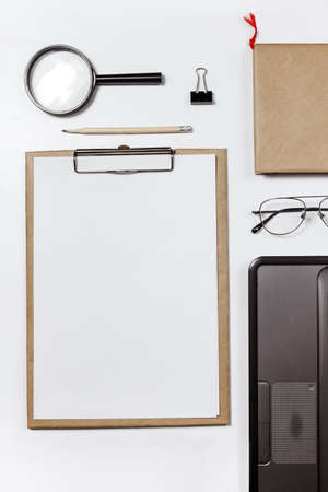 Flat lay of stylish male workplace with clip folder, laptop and business accessories on white background. copy spaceの写真素材