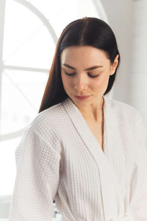 Beauty woman clean healthy skin, natural make-up spa cosmetology concept long dark hair. Woman in white bathrobe.の写真素材